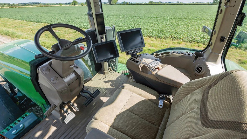 Interior of a John Deere 6M tractor cab showing operator controls