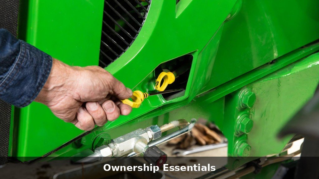 Owner checking engine oil on a John Deere 1023E during routine maintenance